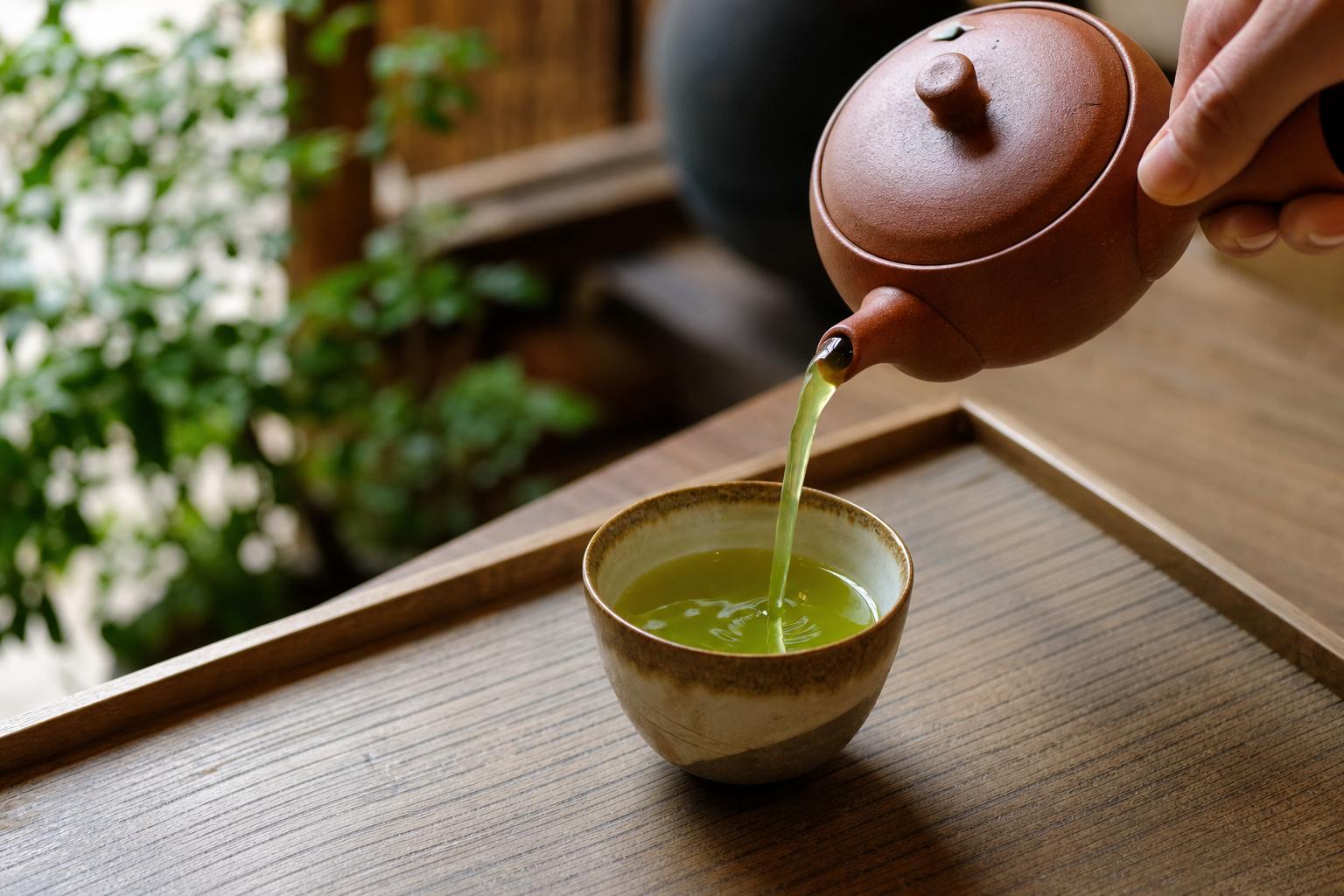 Tea pouring into a ceramic cup